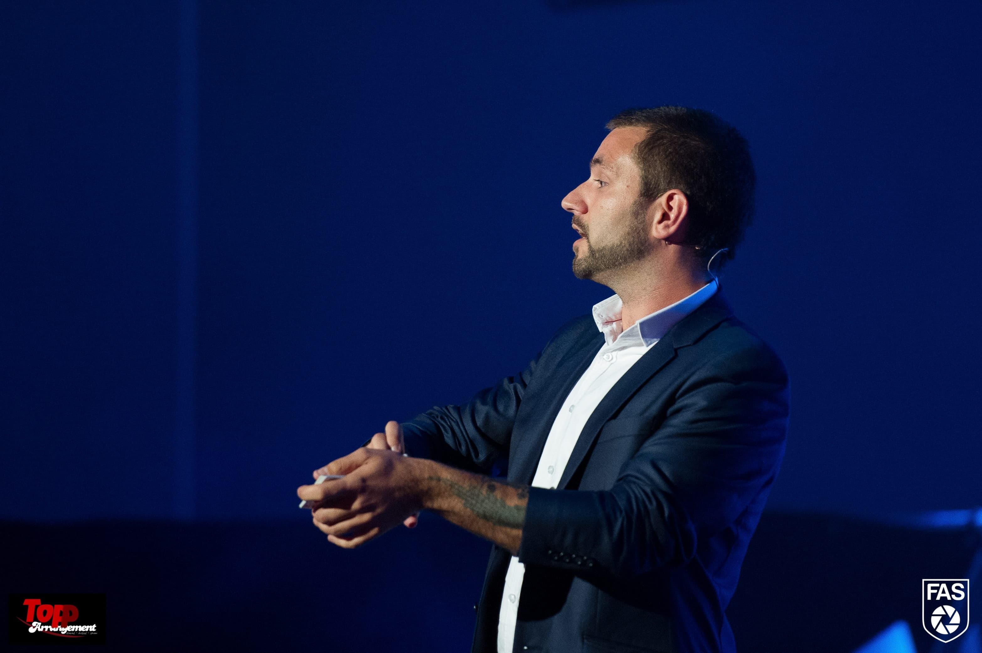Kevin Lunde formidler fra scenen foran et blått sceneteppe